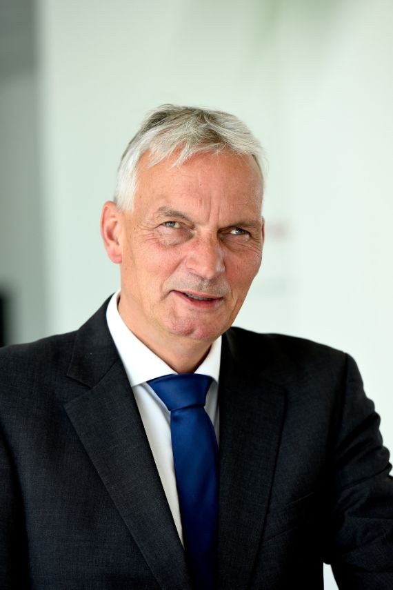 Pressemitteilung Ein Mann in einem dunklen Anzug.
