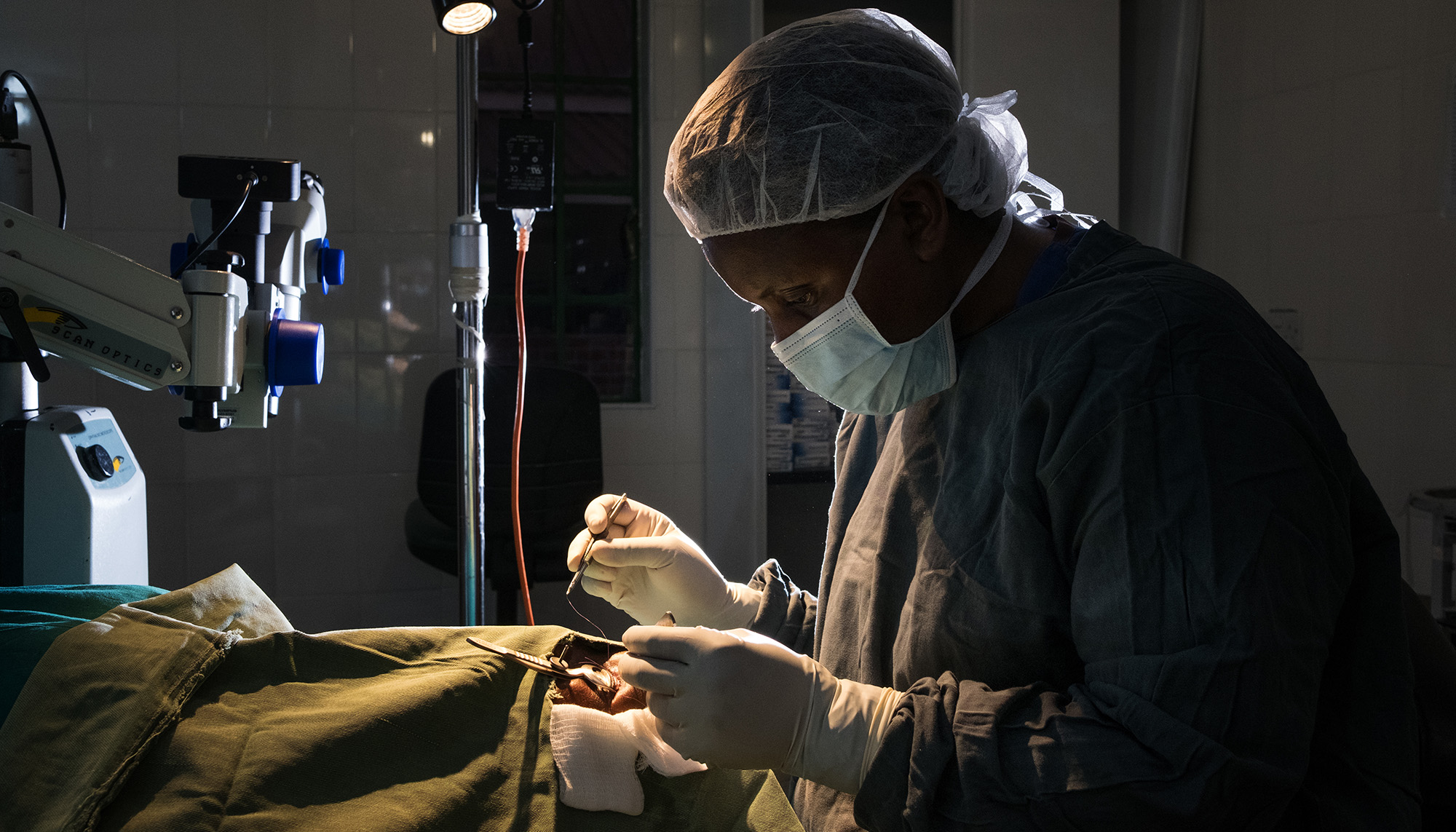Ein Chirurg beugt sich über den Patienten auf dem OP-Tisch.